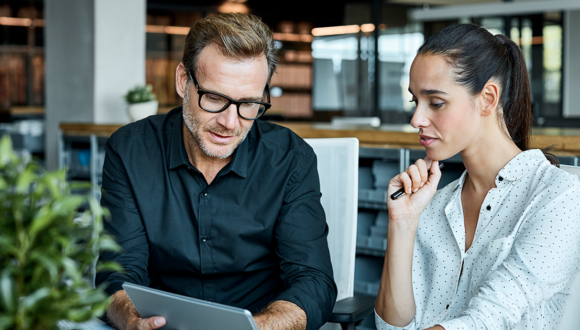 Two people look at a tablet